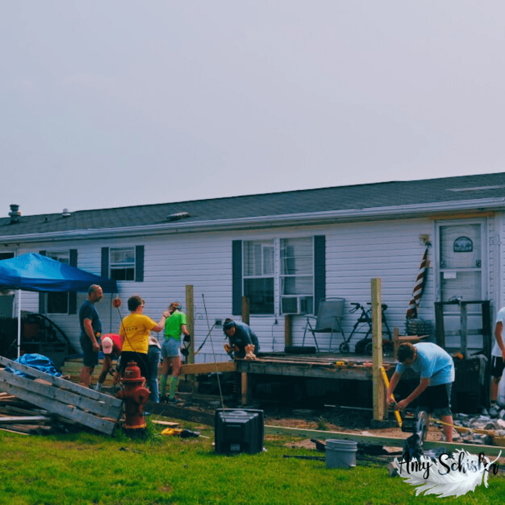 Teens and adults on a mission team build a wheelchair ramp for someone in need.